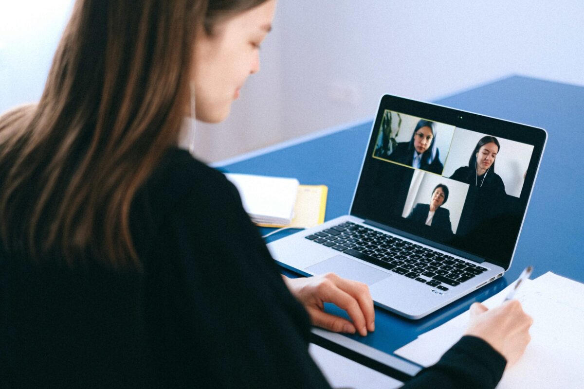 woman having a virtual meeting with three other coworkers