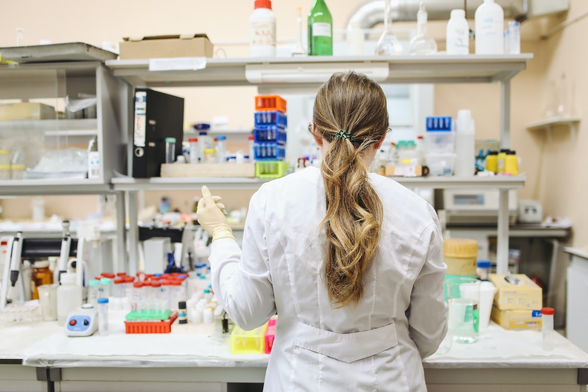 A female scientist working with her back turned in a lab with various samples and equipment devices