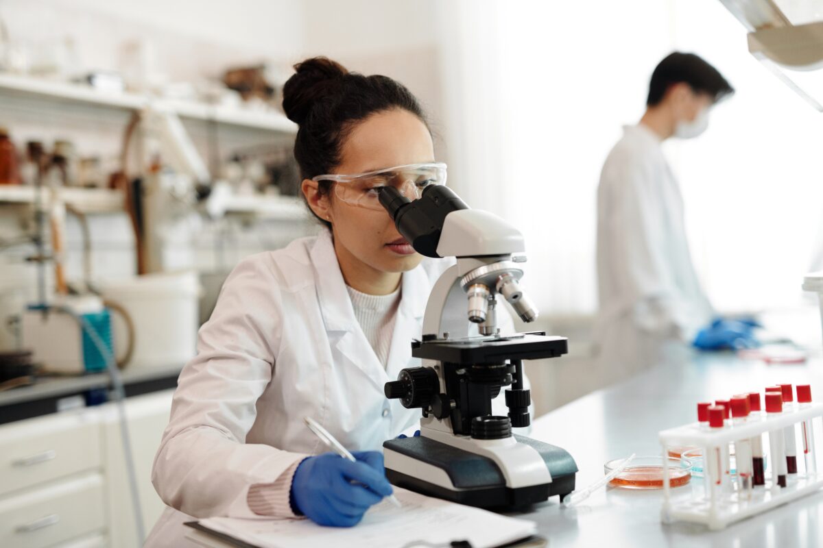 woman at a microscope in a lab setting